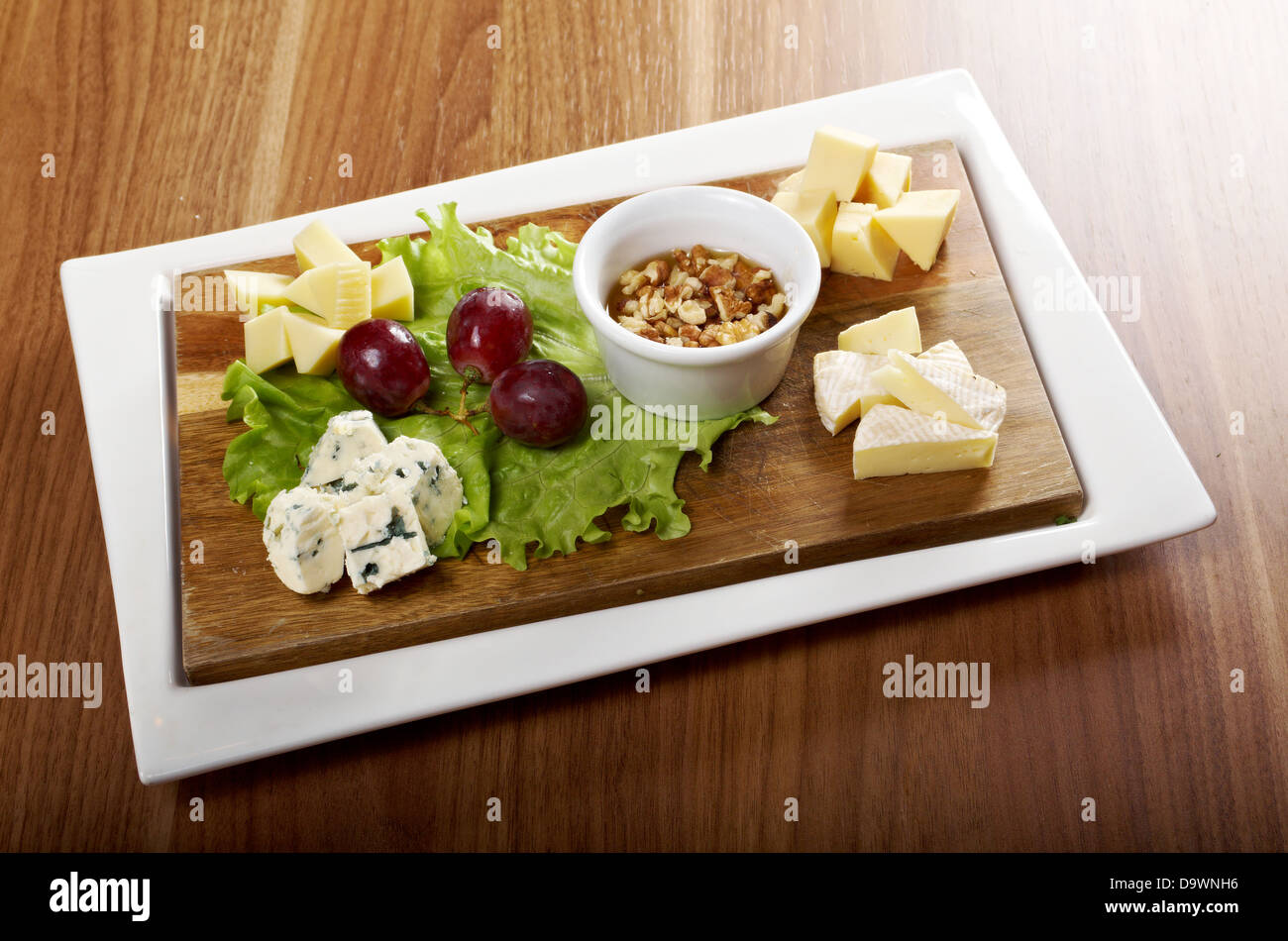 Vari tipi di formaggio sul piatto di legno Foto Stock