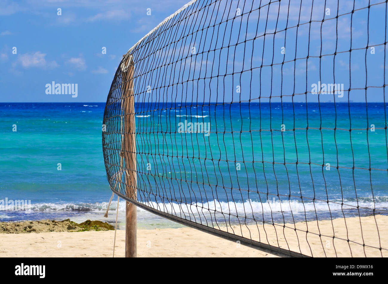 A beach volley net flutti nel vento su un vuoto spiaggia tropicale. Per i viaggi di piacere il concetto di vacanza Foto Stock