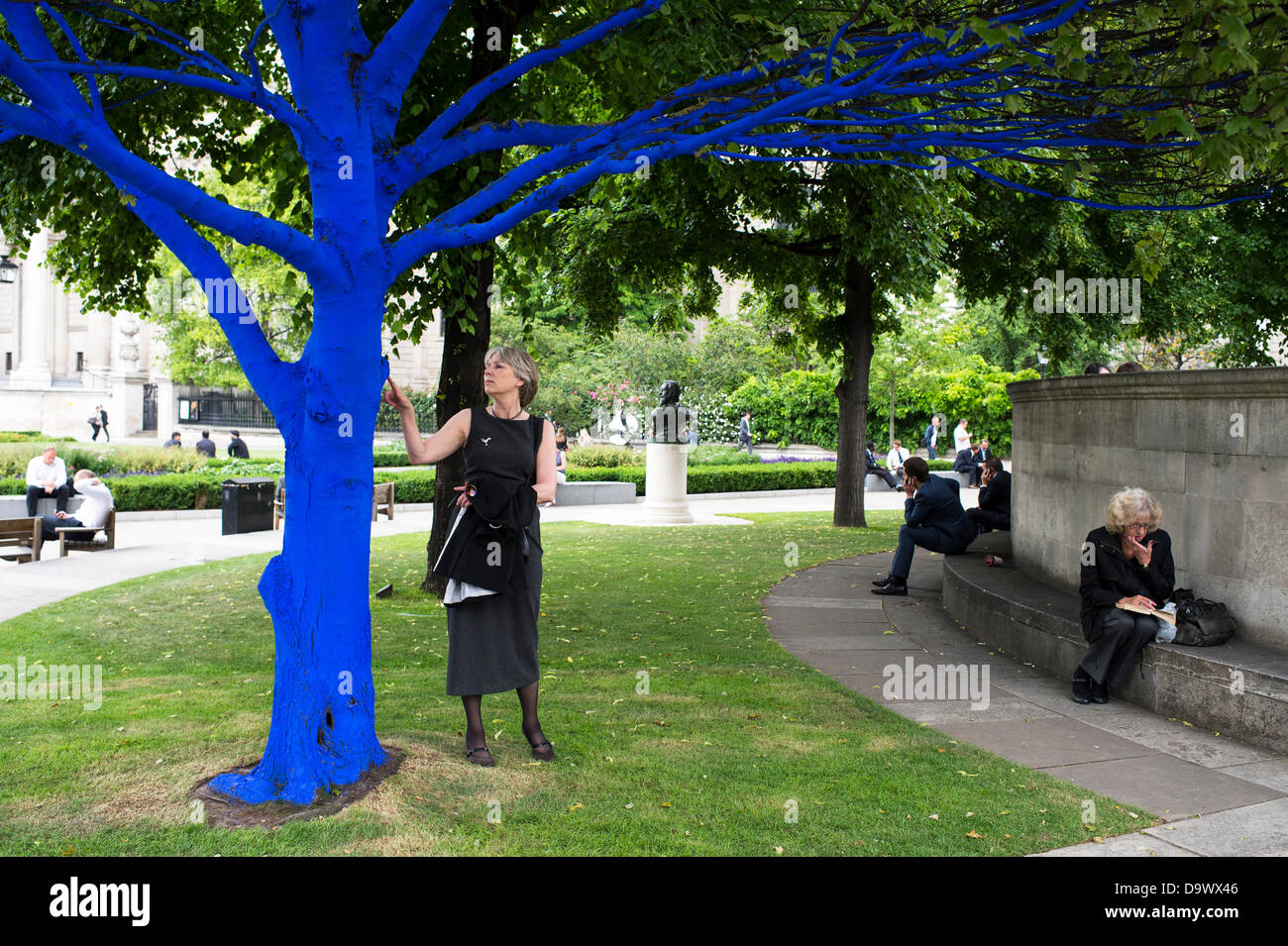 Londra, Regno Unito. Il 27 giugno 2013. Festival dei giardini, città di Londra. Le persone interagiscono con uno degli alberi dipinto di blu come parte di blu e di alberi in London arte di installazione. Alberi di carità per le città ha collaborato con artisti internazionali, Konstantin Dimopoulos, che è venuto fino al Blue Tree concetto. L idea del progetto è di convincere la gente a smettere di avviso e gli alberi nell'ambiente urbano. Come città popolazioni crescano, il numero di alberi di urbano diminuisce. Ma molte persone arrestato oggi a guardare, toccare e fotografare uno degli alberi di blu. Credito: Allsorts Stock Photo/Alamy Live News Foto Stock