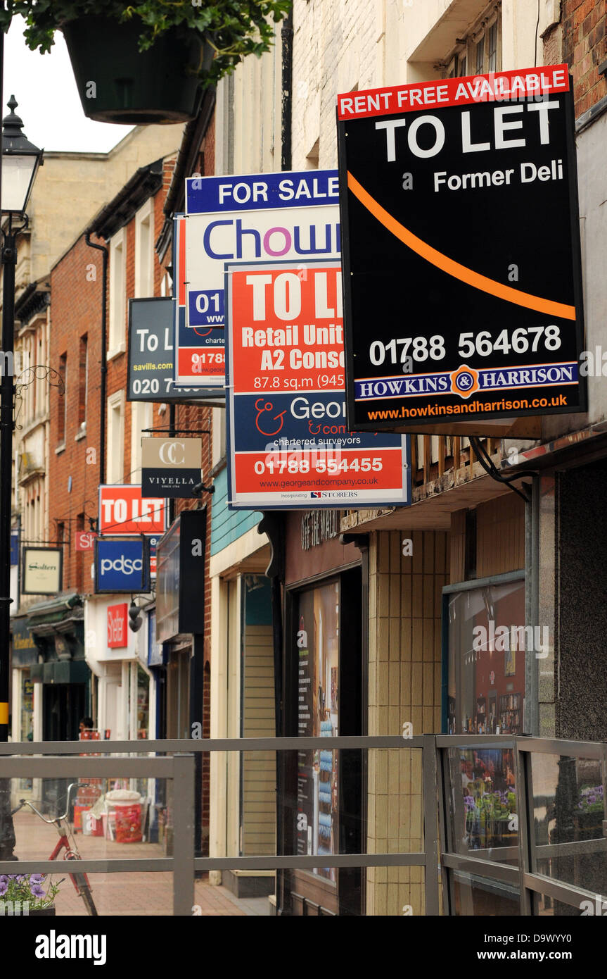 Vuoto insegne appendere sopra vacante negozi di High Street, Rugby, Warwickshire, Regno Unito. Foto Stock