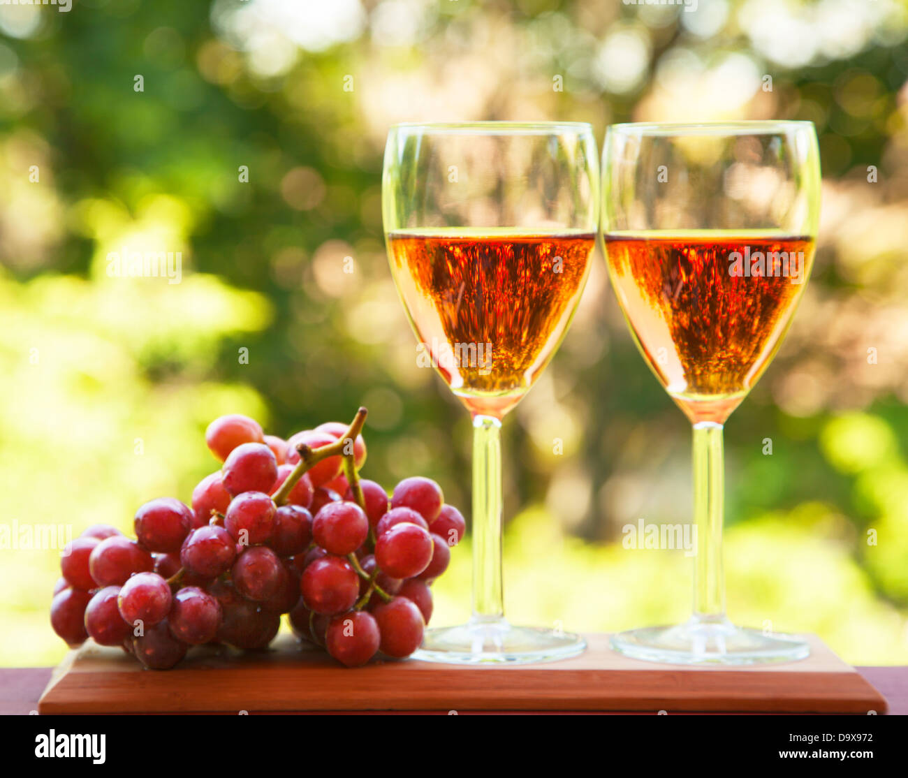 Bicchiere di vino di colore rosa e uva Foto Stock