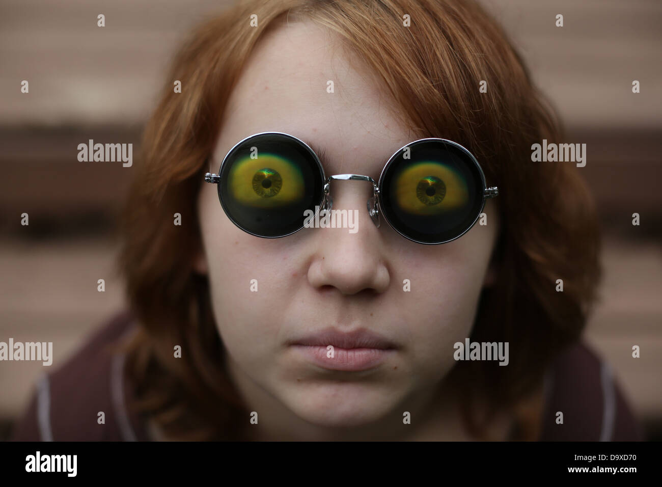Una ragazza adolescente che indossa funny eyeball bicchieri. Foto Stock