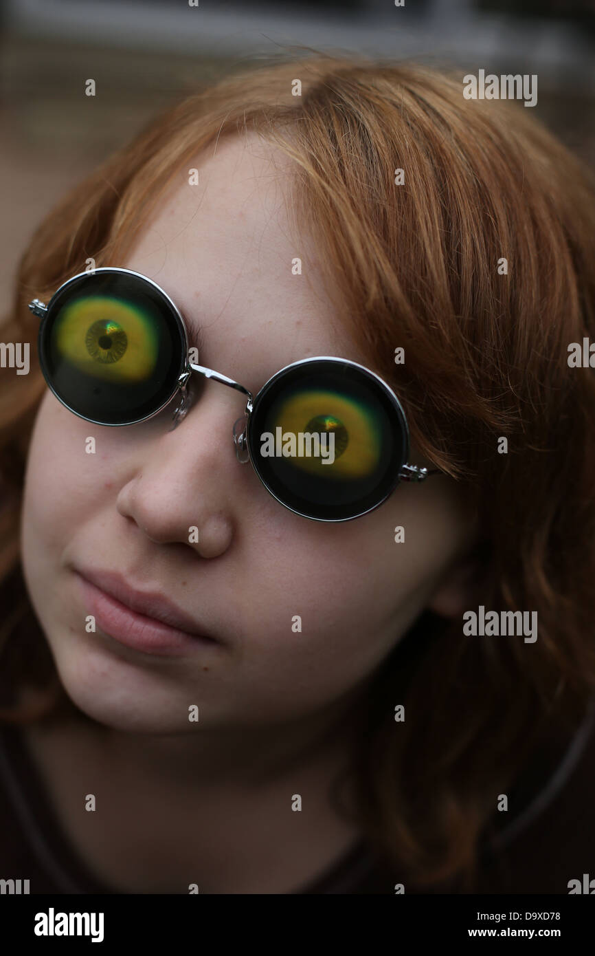 Una ragazza adolescente che indossa funny eyeball bicchieri. Foto Stock