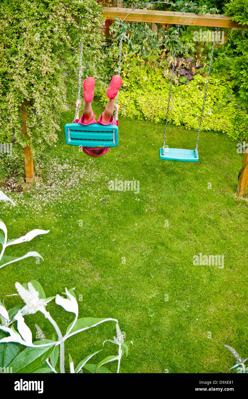 Ragazzo su backyard swing Foto Stock