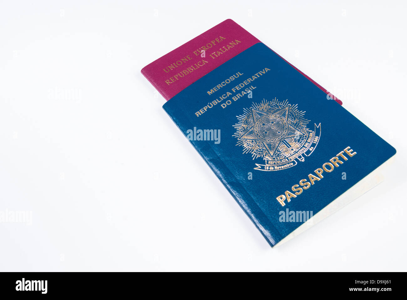 Passaporto brasiliano in prospettiva con passaporto italiano all'interno. Isolato su sfondo bianco Foto Stock