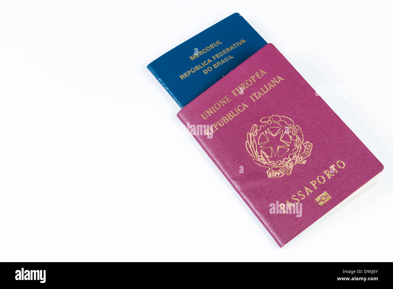 Passaporto italiano in prospettiva con passaporto brasiliano all'interno. Isolato su sfondo bianco Foto Stock