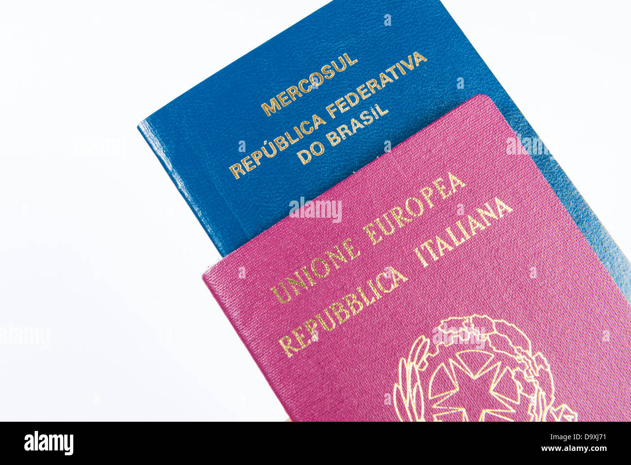 Close-up di passaporto italiano con passaporto brasiliano all'interno. Isolato su sfondo bianco Foto Stock