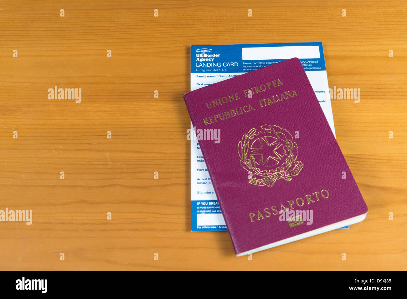 Passaporto italiano con UK carta di sbarco all'interno. Isolato sul modello  in legno Foto stock - Alamy