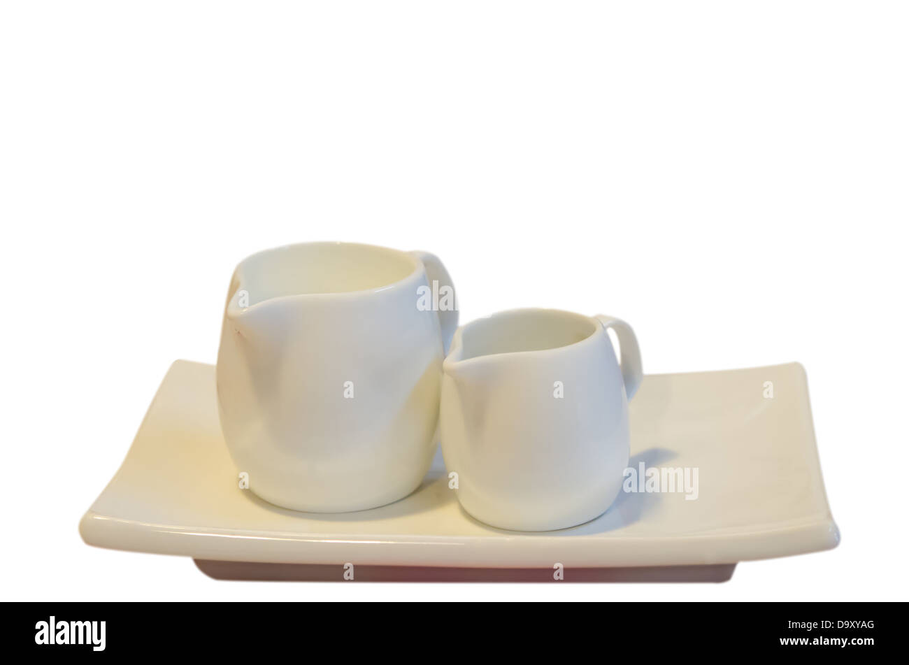Bianco latte caraffa sulla piastra su sfondo bianco Foto Stock