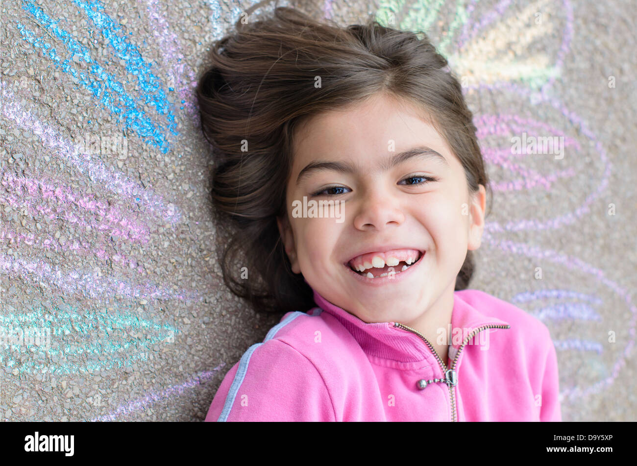 Felice ragazza con il suo disegno sul marciapiede Foto Stock