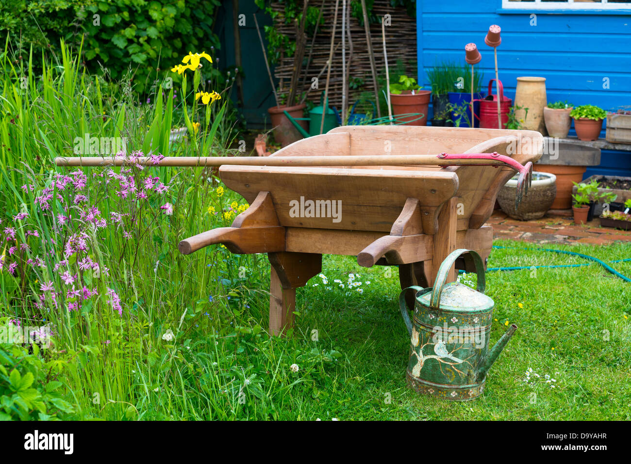 Una carriola da giardino si trova nel cortile di una fattoria vicino a  strumenti aggiuntivi
