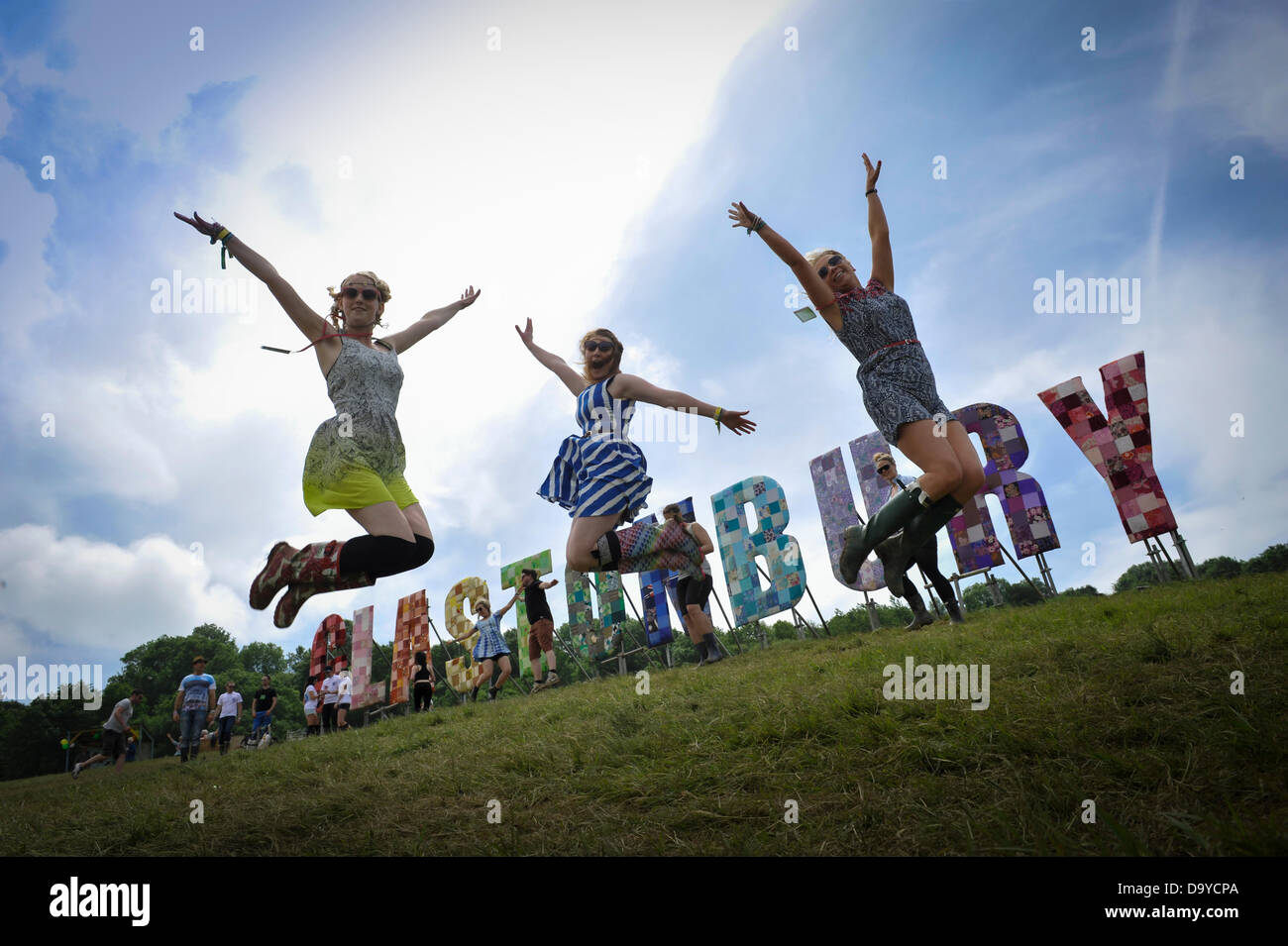 Glastonbury, Regno Unito. Il 28 giugno 2013. GLASTONBURY FESTIVAL DI MUSICA i frequentatori del festival salta con entusiasmo da delle lettere di grandi dimensioni che esplicitino Glastonbury. La sua stima 200.000 persone parteciperanno alla Quattro giorni di Glastonbury Festival che si svolge presso l'azienda agricola degna, Pilton Somerset. Giugno 28. 2013. GLASTONBURY FESTIVAL DI MUSICA PILTON, Somerset, Inghilterra, UK Credit: Alistair Heap Alamy/Live News Foto Stock