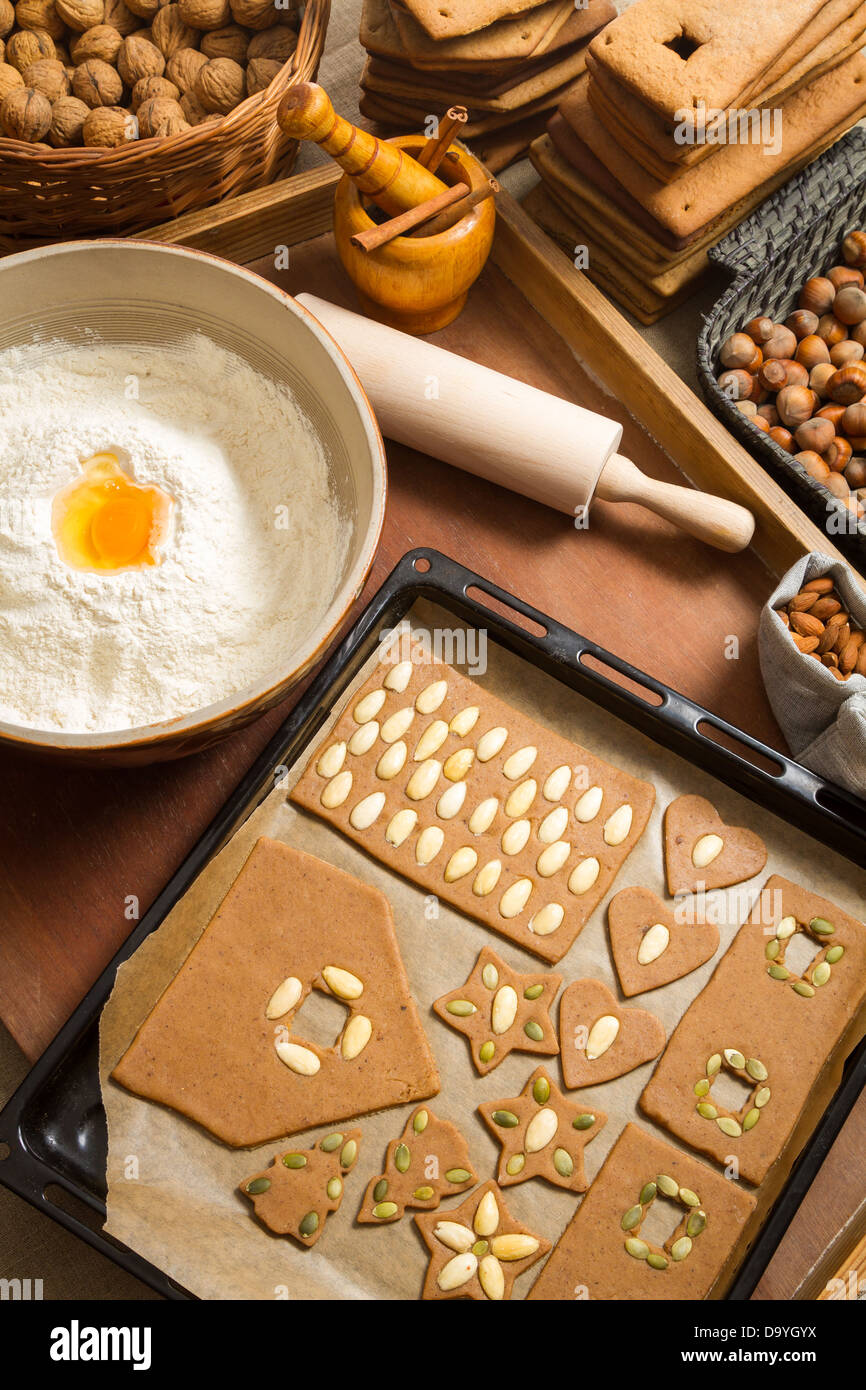 La decorazione di gingerbread cookies i dadi appena prima della cottura Foto Stock