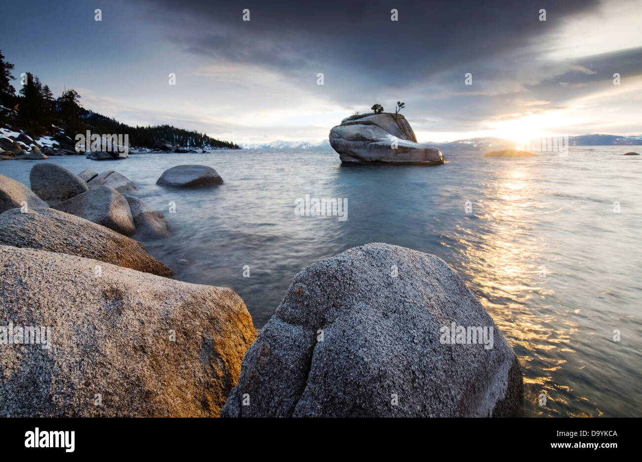 Il tramonto si riflette del lago Tahoe e massi di granito sulla sponda orientale in una ubicazione nascosta noto come Bonsai Rock, NV. Foto Stock