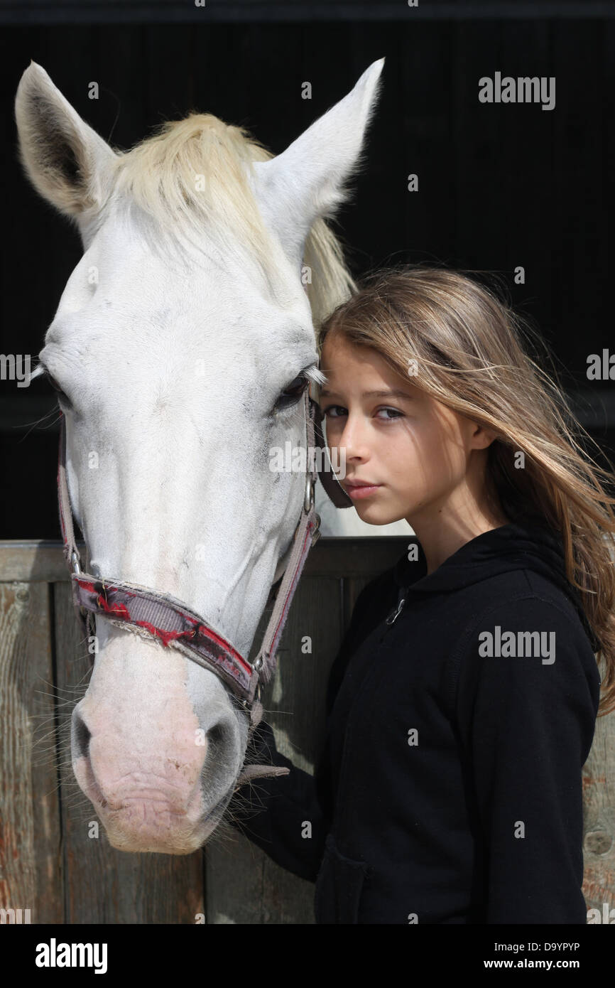 Bella adolescente con pony bianco Foto Stock