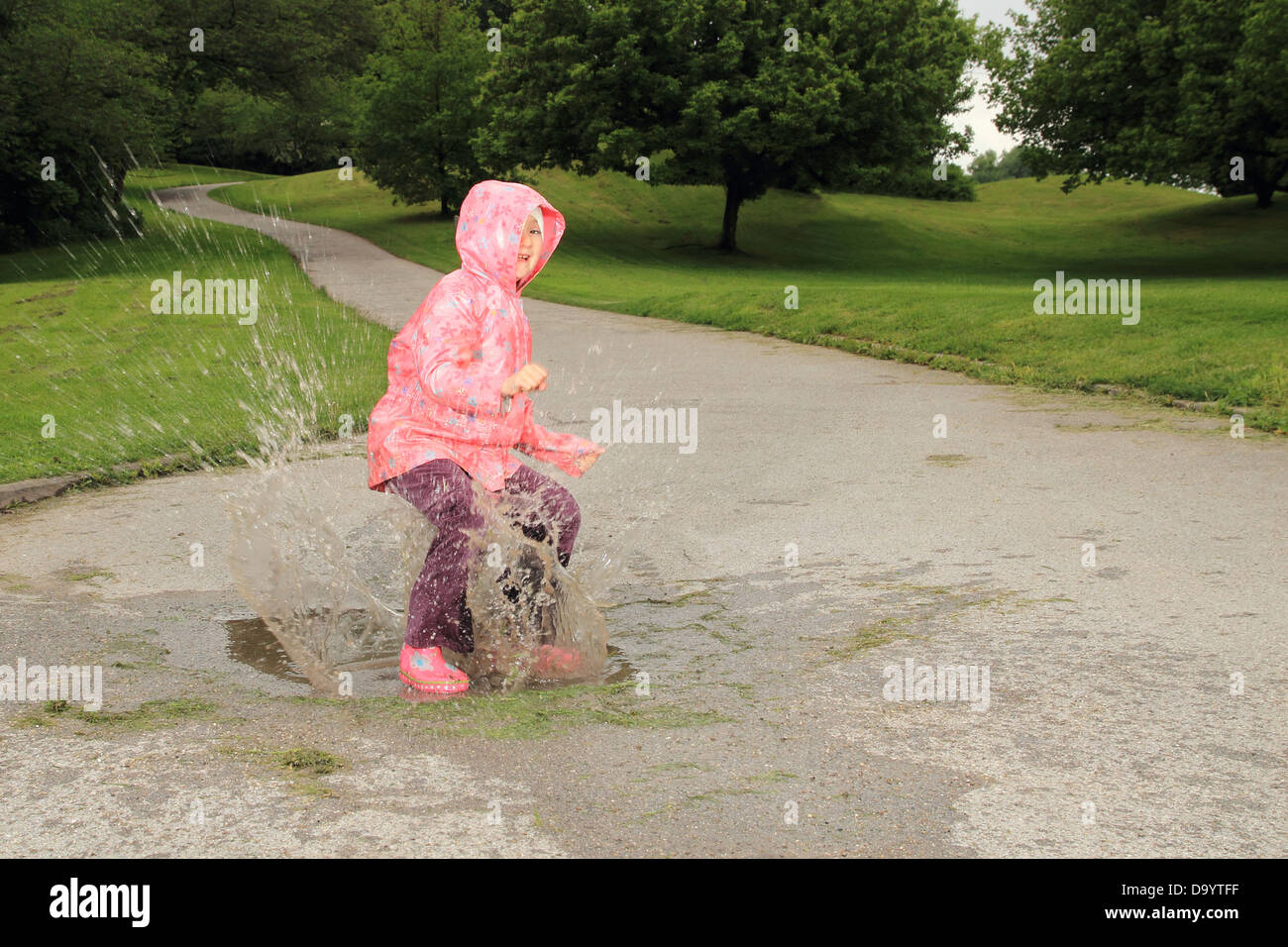 Bambini il salto in una pozza Foto Stock