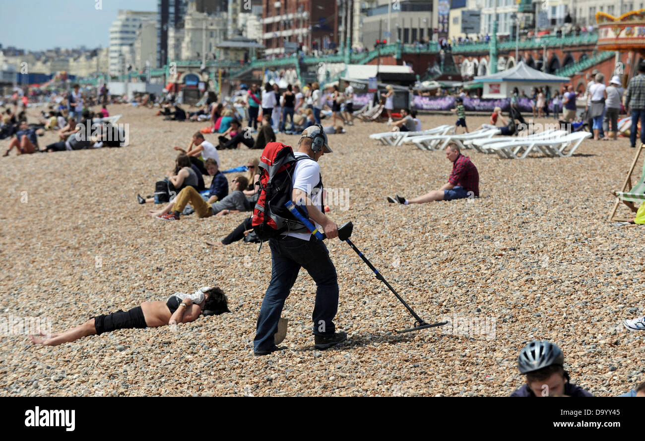 Brighton Regno Unito 29 Giugno 2013 - un cacciatore di tesori con un metallo dispositivo di rilevamento passeggiate fra le lucertole da mare sulla spiaggia di Brighton come hanno goduto il caldo oggi fotografia scattata da Simon Dack/Alamy Live News Foto Stock