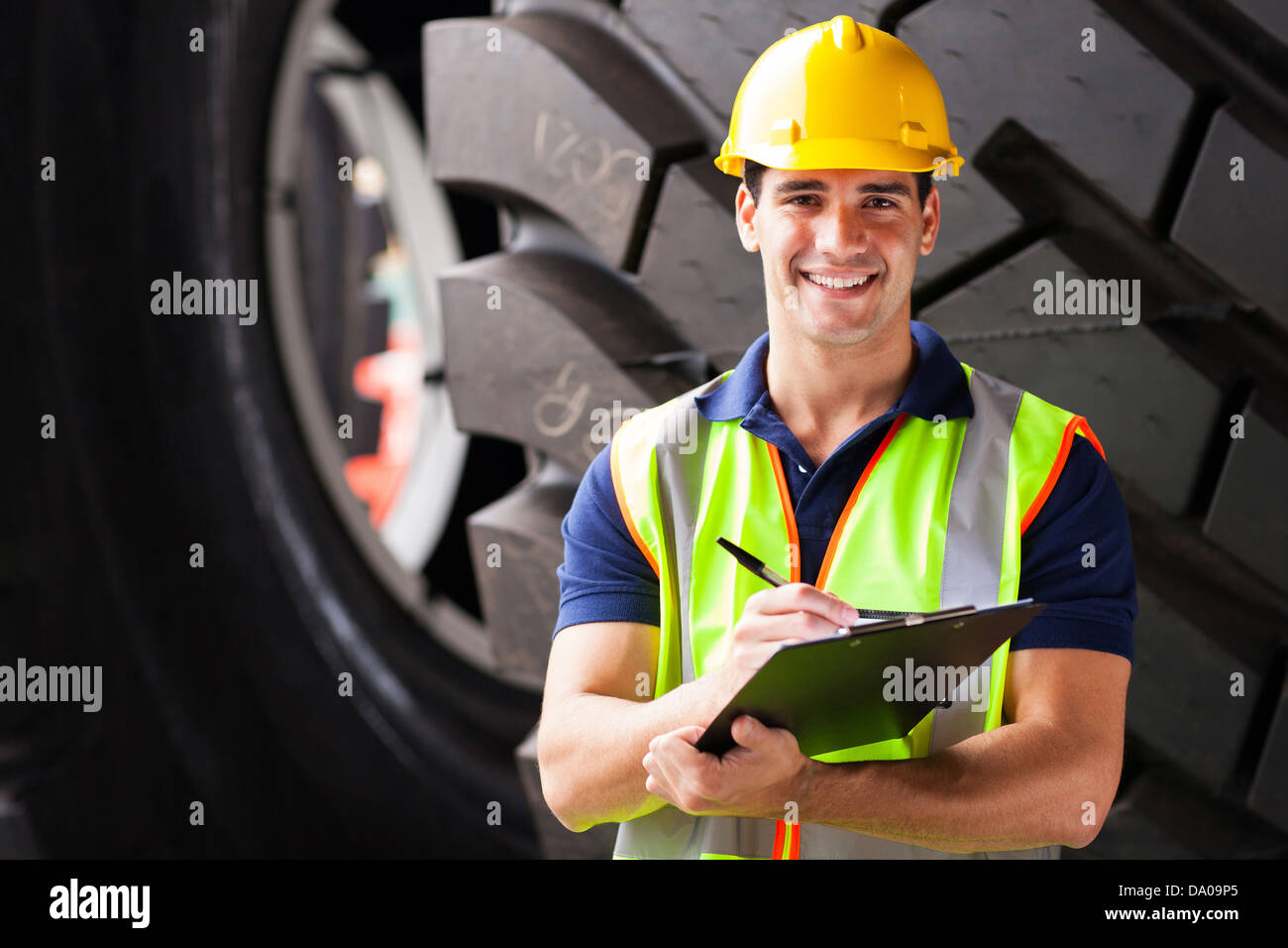 Ritratto di società di navigazione dipendente in piedi nella parte anteriore dei pneumatici industriali Foto Stock