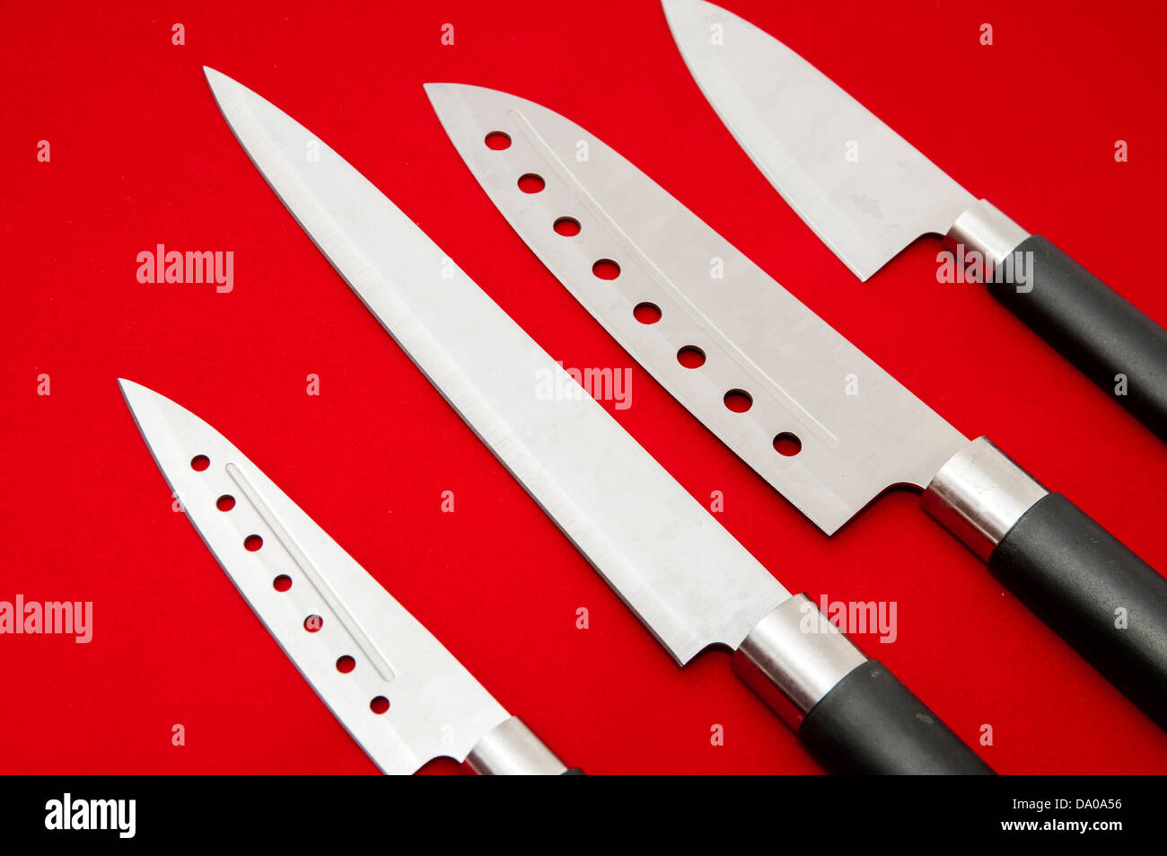 Coltelli da cucina su uno sfondo rosso Foto Stock