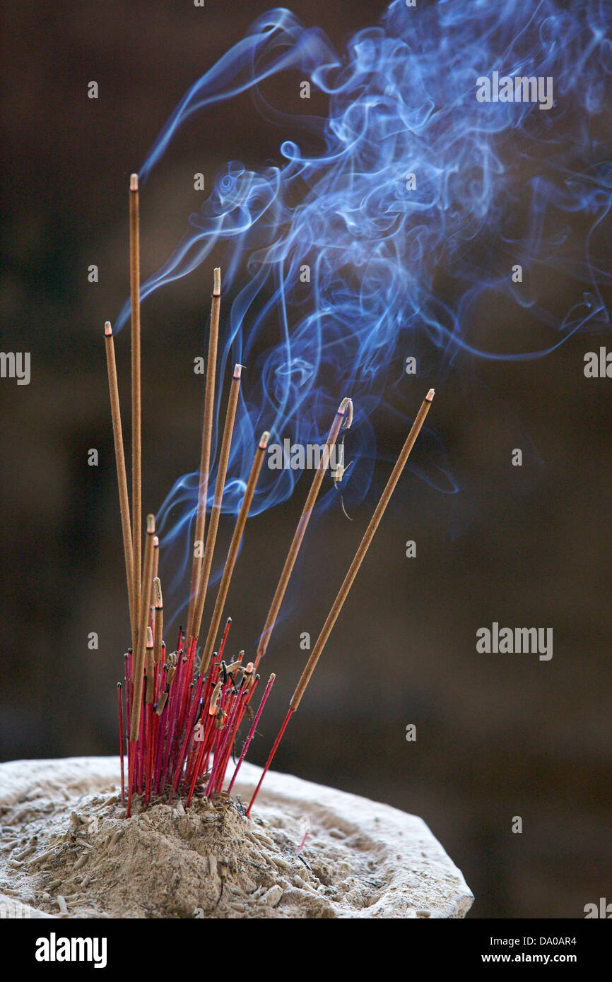 Brucia Incenso con blu fumo di curling in un tempio Foto Stock