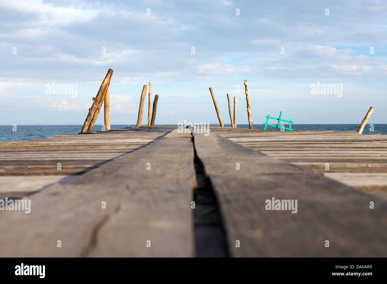Un molo in legno scompare nel lontano blu del mare e del cielo Foto Stock