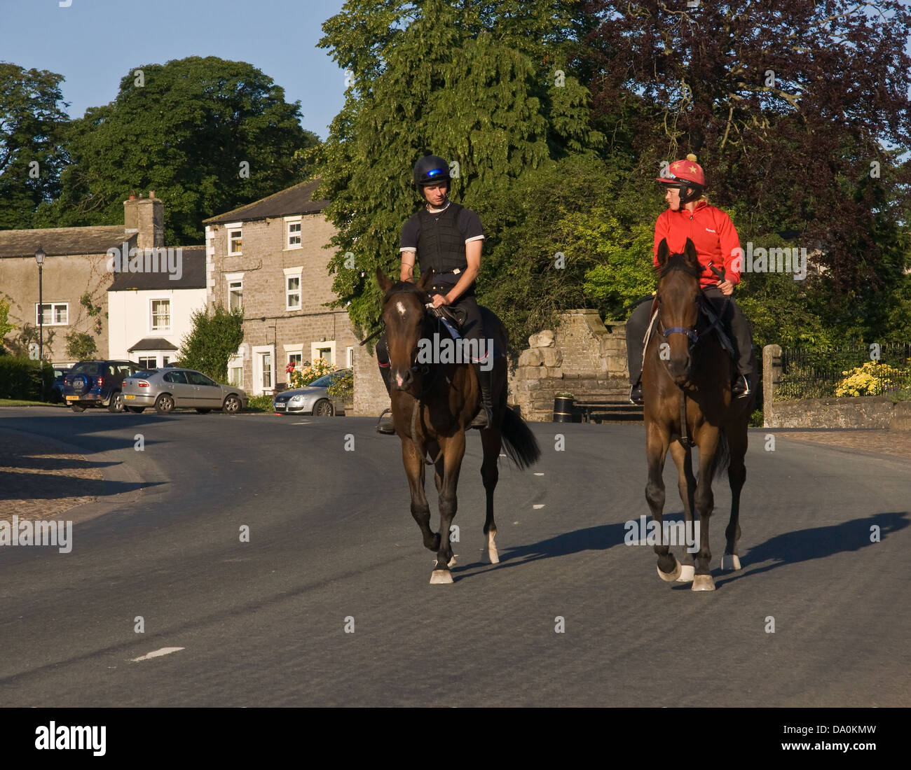 Ai cavalli da corsa essendo cavalcato attraverso Middleham, North Yorkshire, sulla strada del ritorno dalla formazione galoppa. Foto Stock
