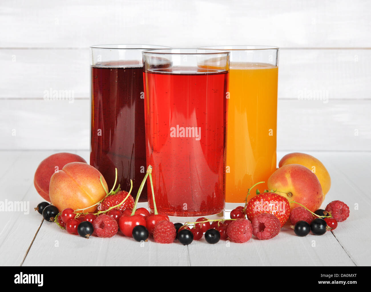 Succo di bacca in bicchieri con frutti di bosco freschi su sfondo di legno Foto Stock