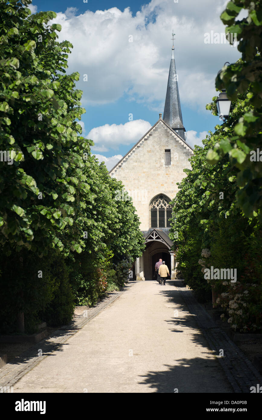 Una vista turisti in entrata alla chiesa al Fontevraud, dal percorso che conduce ad esso. Valle della Loira, Francia Foto Stock