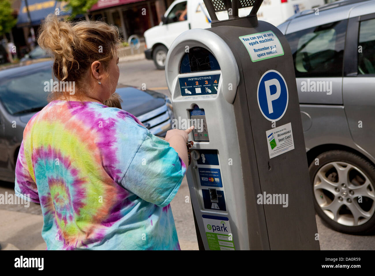 Una donna che gestisce un sistema elettronico di parcheggio macchina Foto Stock