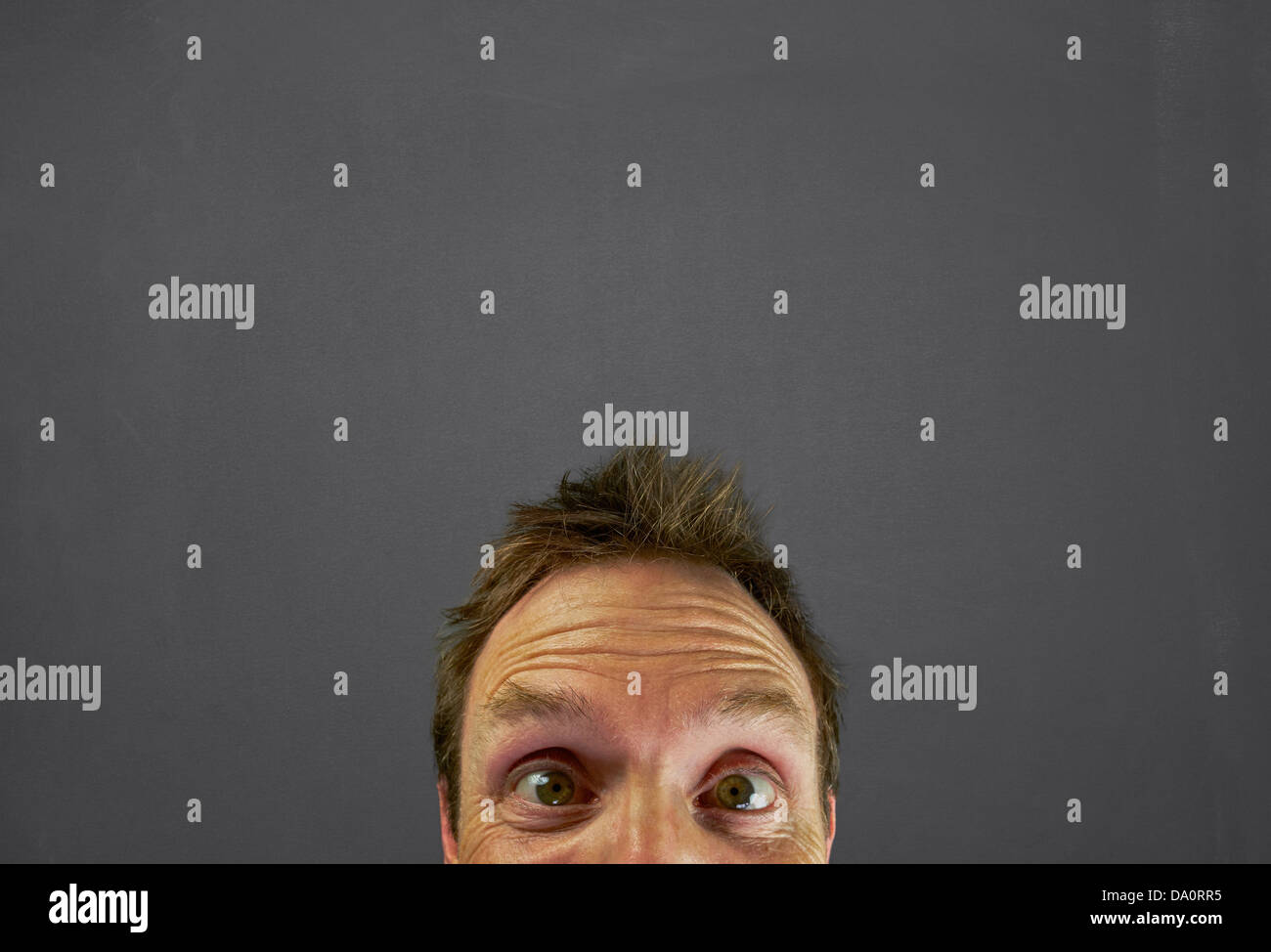 Testa di uomo di fronte a una lavagna con un blankspace per scrivere o disegnare un messaggio di cui sopra. Foto Stock