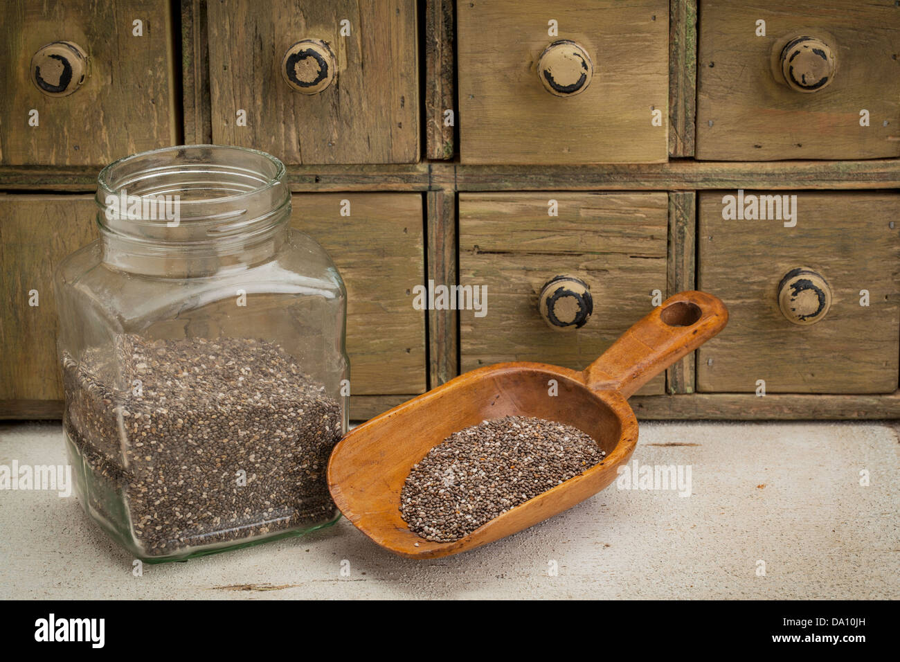 Il vaso e scoop di chia semi con un primitivo speziale armadio con cassetti Foto Stock