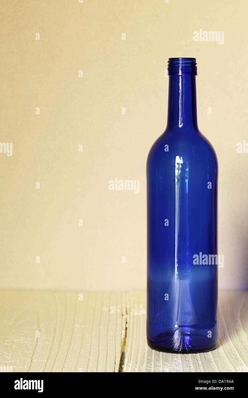Bottiglia di vino sul tavolo di legno con lo sfondo della parete Foto Stock