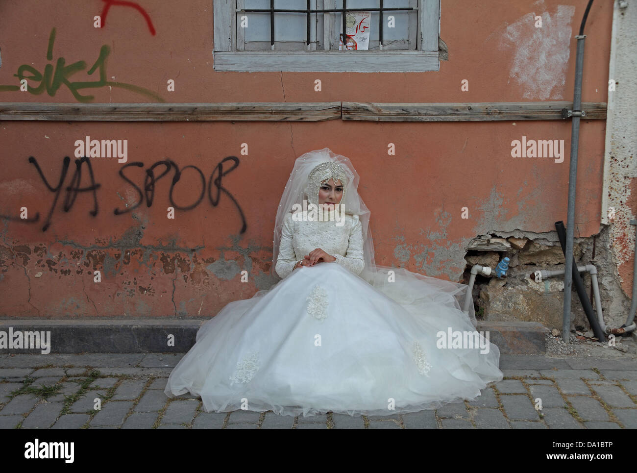 Un musulmano sposa siede in attesa in una sporca backstreet in Turchia Antalya Foto Stock