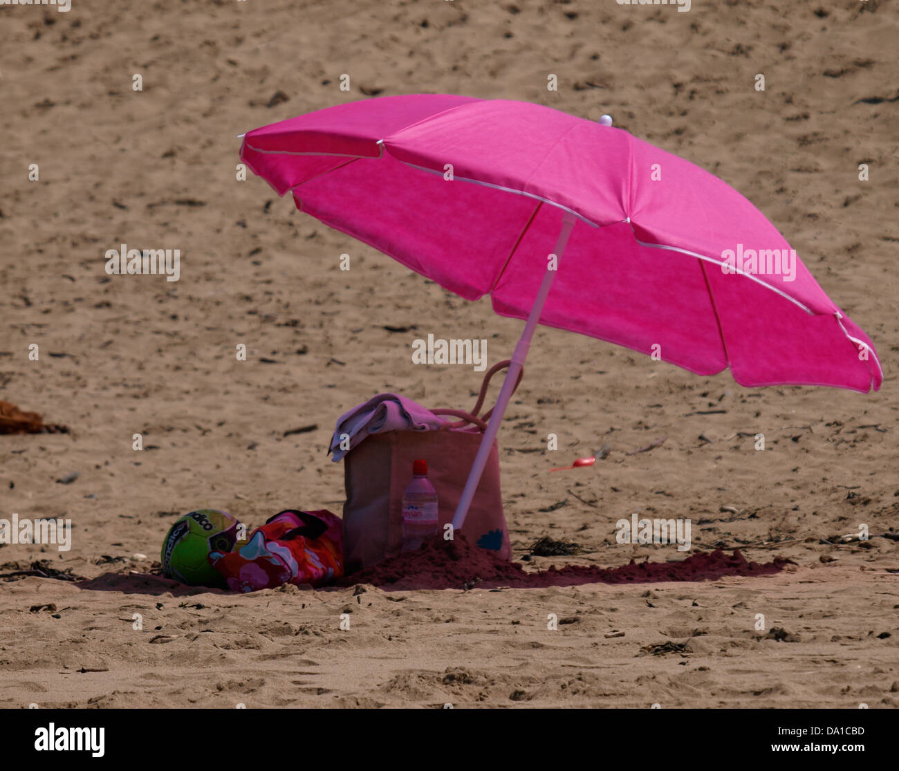 Rosa ombrellone in spiaggia, Cornwall, Regno Unito 2013 Foto Stock