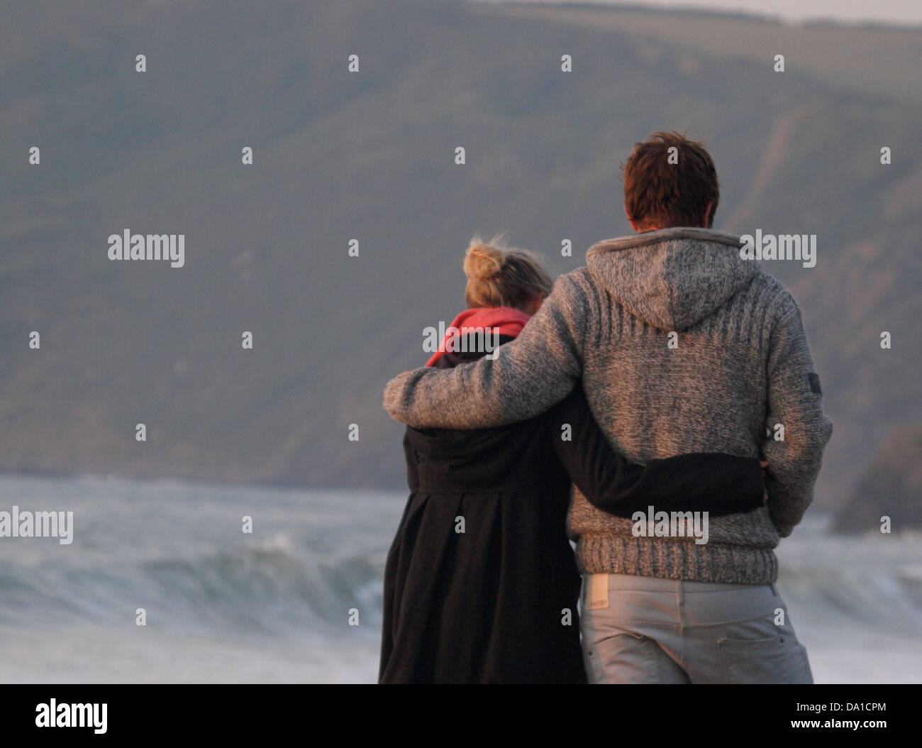Amorevole coppia giovane a piedi lungo la spiaggia di sera, Cornwall, Regno Unito 2013 Foto Stock
