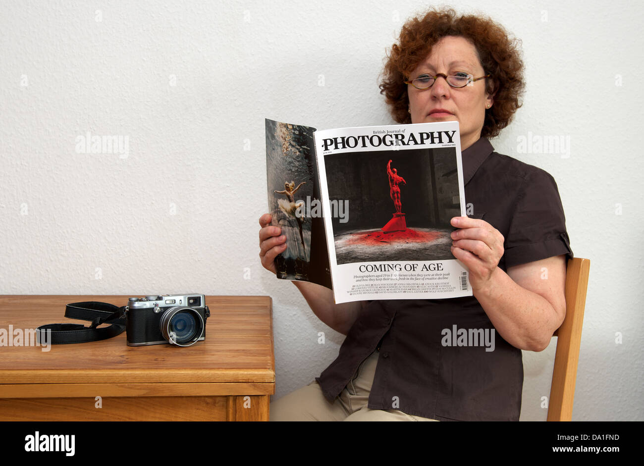 Fotografo freelance leggendo una copia del British Journal of Photography magazine Foto Stock