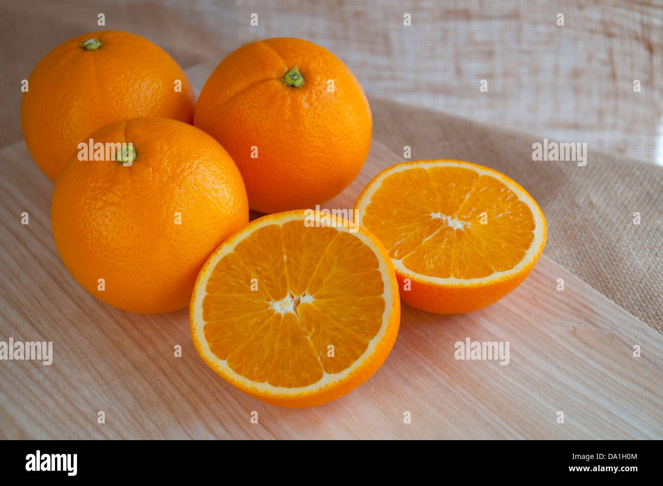 Quattro le arance, uno di loro tagliare in due metà. Ancora in vita. Foto Stock
