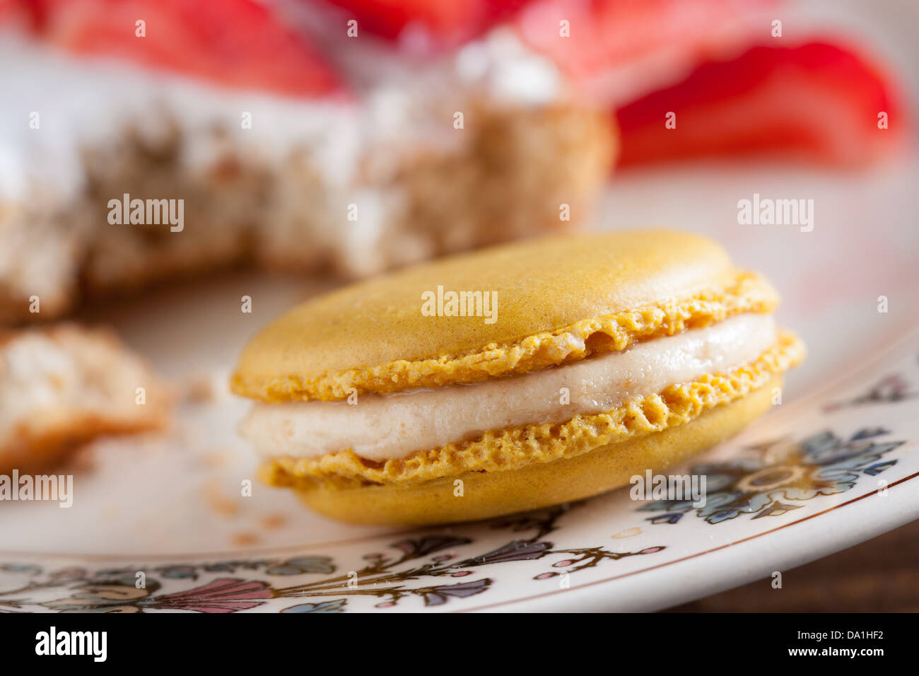 Giallo limone o pralina macaron su un romantico piatto di fiori di close-up Foto Stock