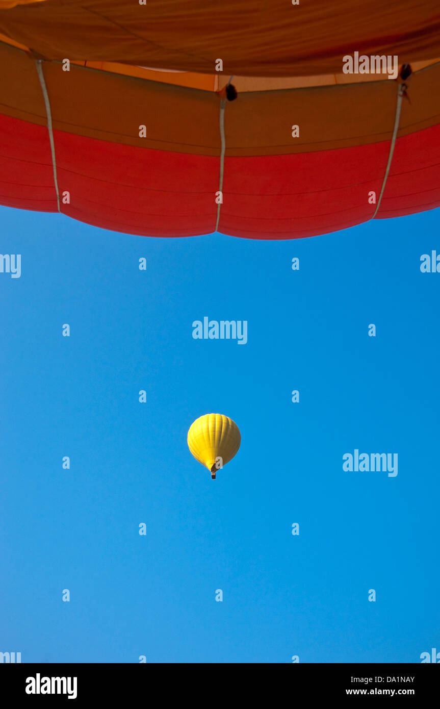 Vista verticale di due mongolfiere in volo contro un cielo blu. Foto Stock