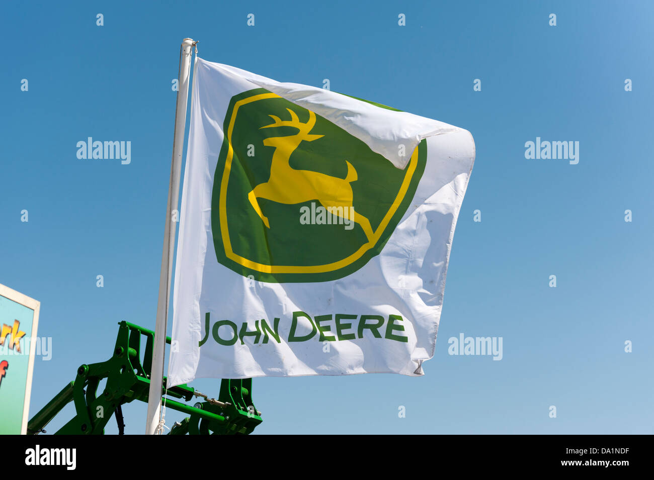 Un John Deere macchine agricole stand presso il Royal Cornwall Show con una bandiera della società e del logo Foto Stock