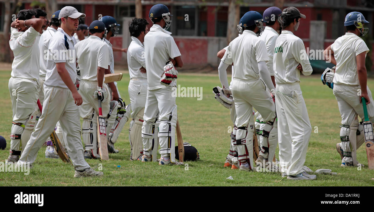 Cricket giocatore indossa bianco uniforme e focalizzata sul gioco Foto Stock