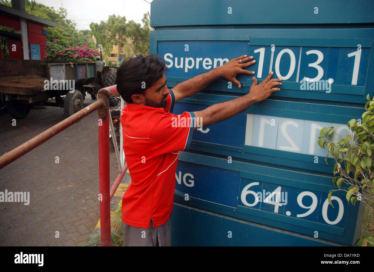 La stazione di benzina Il dipendente mostra i nuovi prezzi di prodotti petroliferi in corrispondenza di una stazione di benzina a Karachi il lunedì, 01 luglio, 2013. I prezzi del petrolio si prevede di aumentare fino a Rs3.66 per litro a partire dal 1 luglio, a seguito di fluttuazioni nella globale dei prezzi del petrolio e aumento di velocità generale dell'imposta sulle vendite (GST). Foto Stock