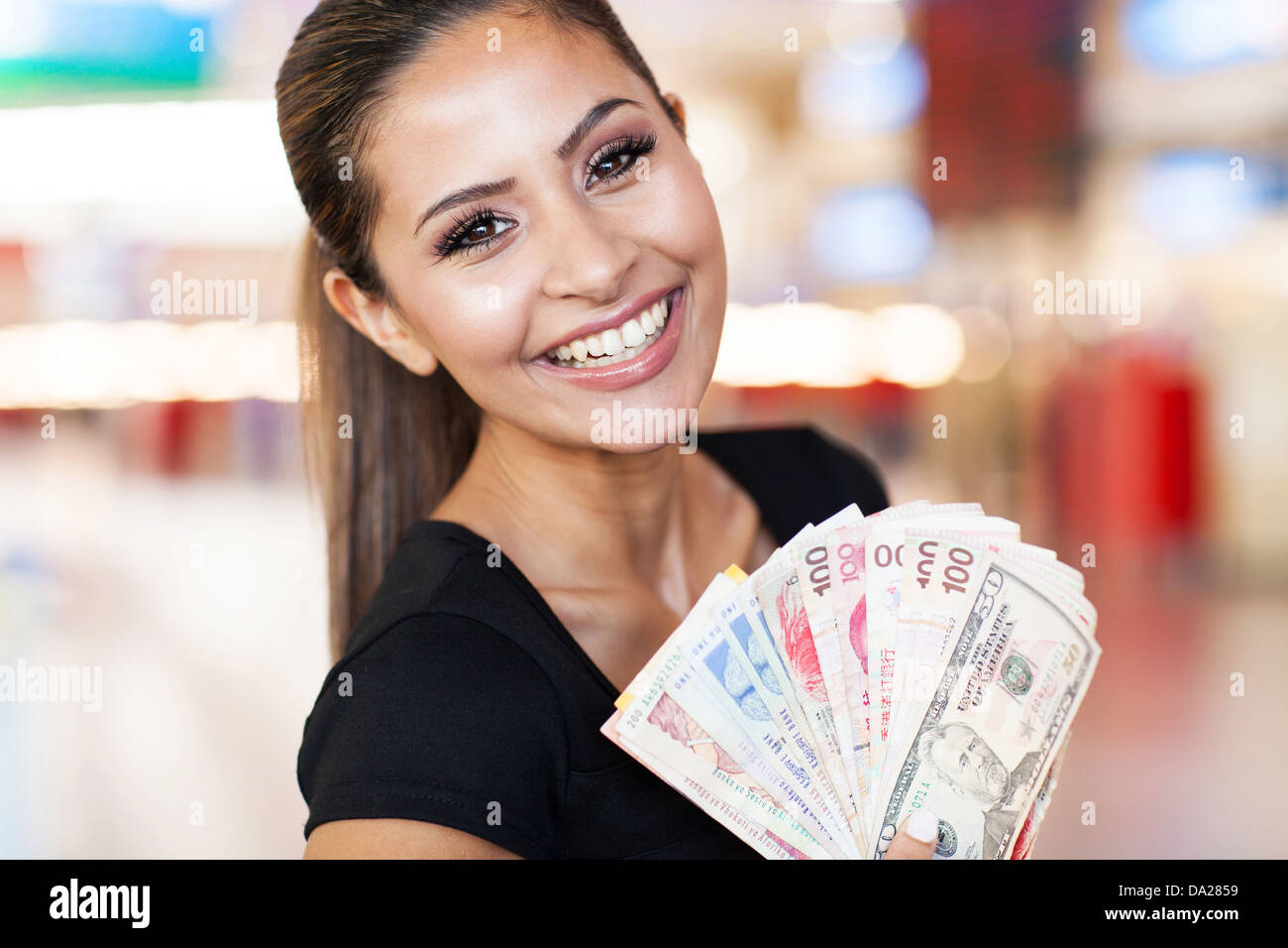 Felice giovane donna mantenendo la ventola di contanti su sfondo del casinò Foto Stock