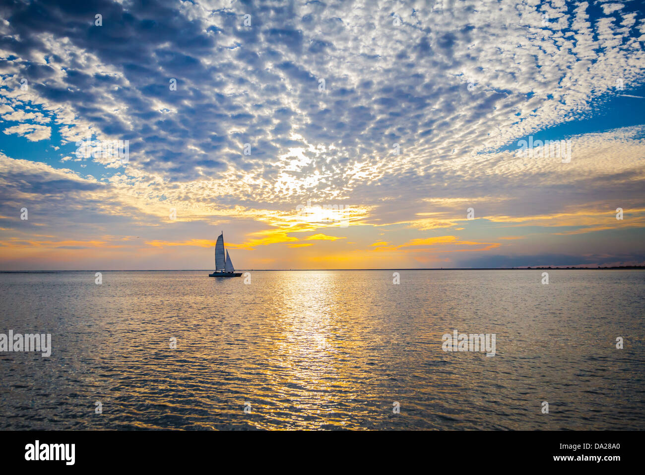 Tranquilla Scena di uno yacht a vela contro il sole. Foto Stock