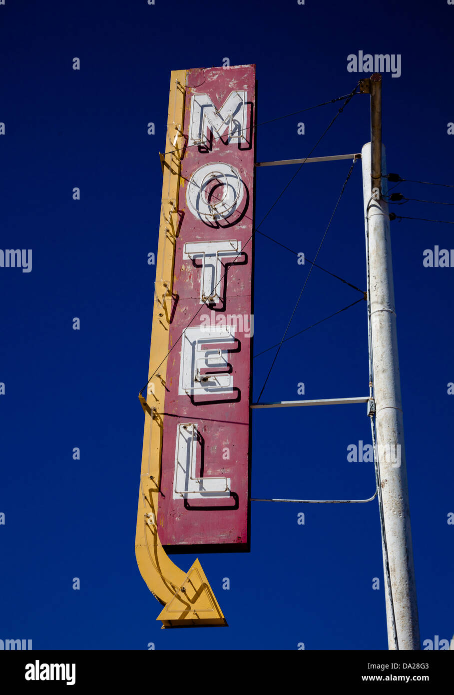 Un motel vintage segno con una freccia nella parte anteriore del cielo blu Foto Stock