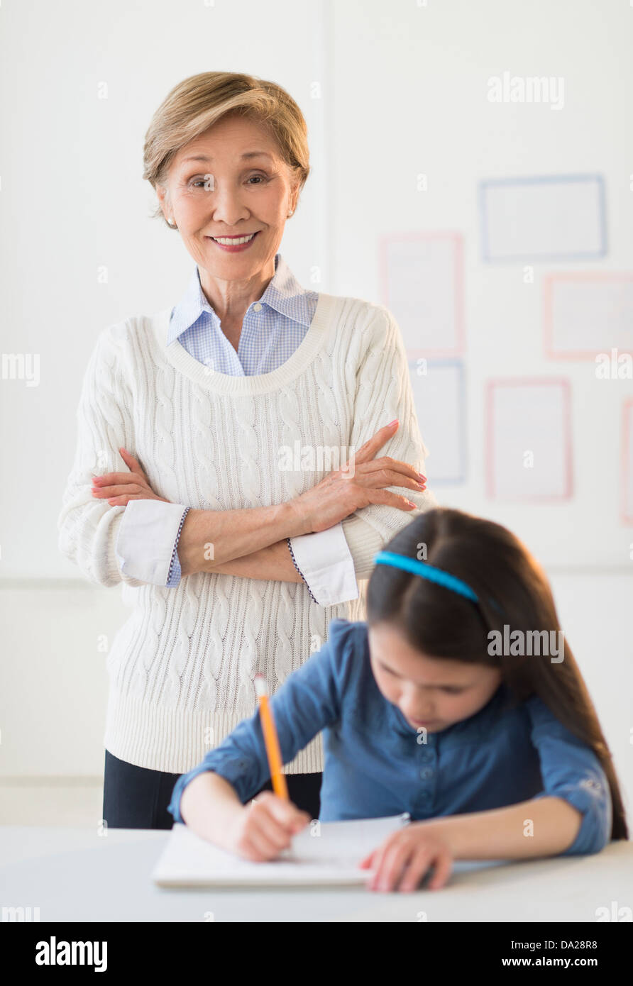 Insegnante e schoolgirl (8-9) a scuola Foto Stock