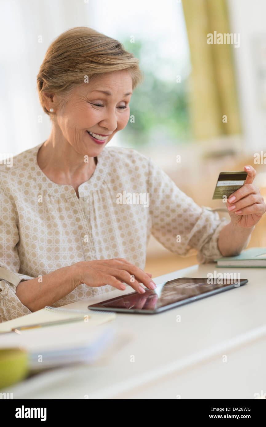 Senior donna shopping online con i tablet pc Foto Stock