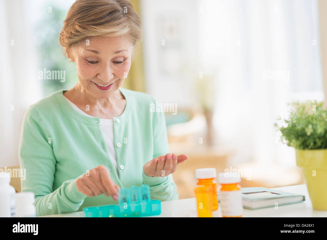 Senior donna organizzando la medicina nella casella Foto Stock