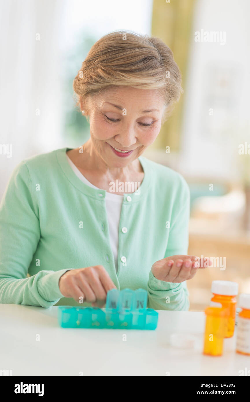 Senior donna organizzando la medicina nella casella Foto Stock