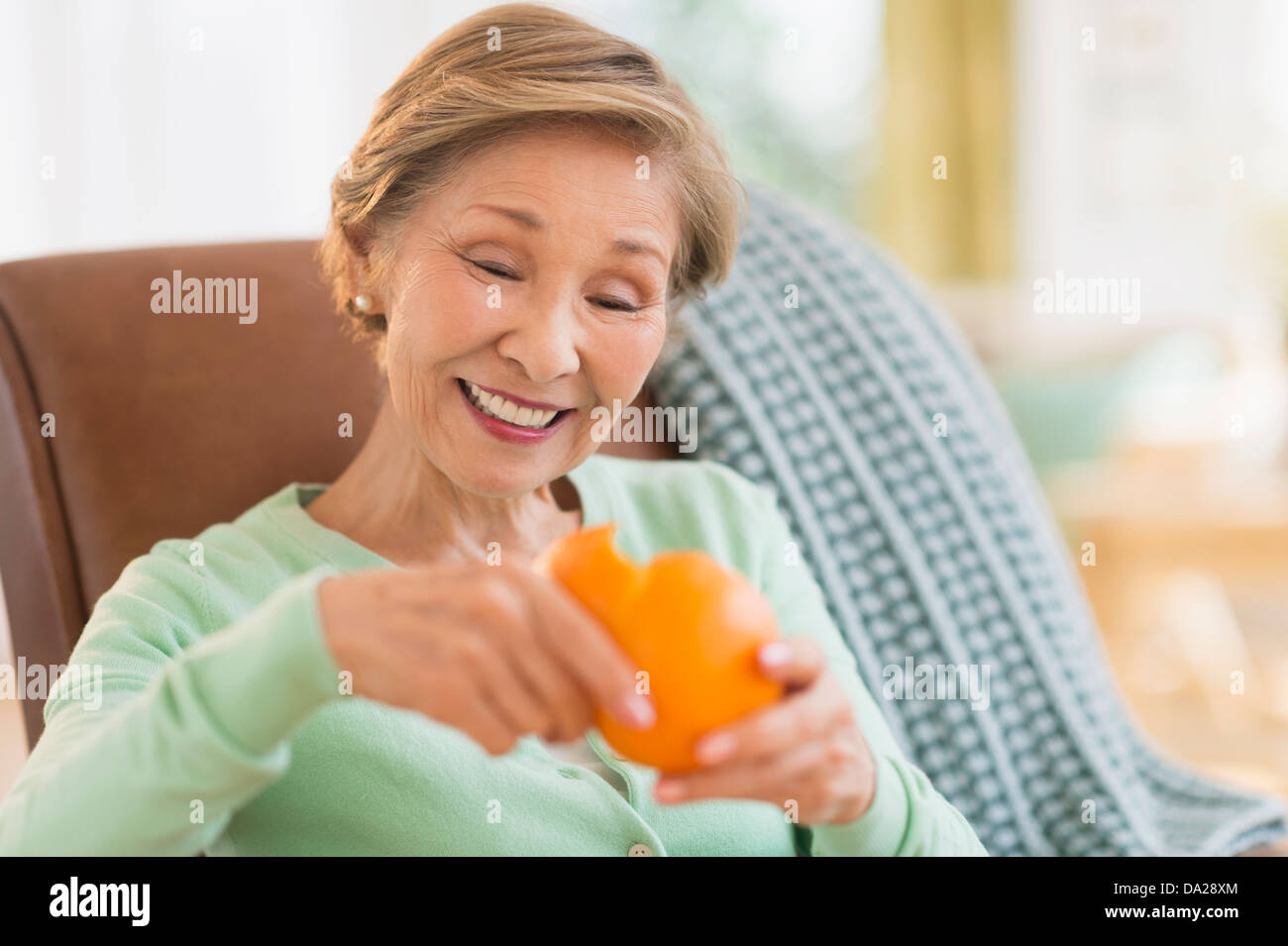 Ritratto di donna senior peeling arancione Foto Stock